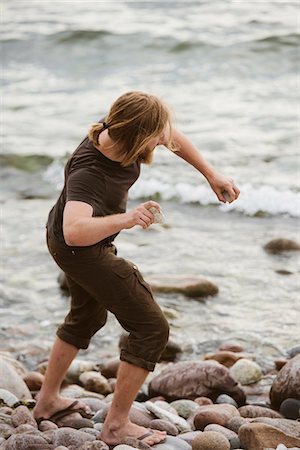 Young man throwing stones on beach, Gotland, Sweden Stock Photo - Premium Royalty-Free, Code: 6102-07768888