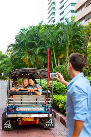 Man taking photo of friends in auto rickshaw Stock Photo - Premium Royalty-Free, Code: 6102-07769100