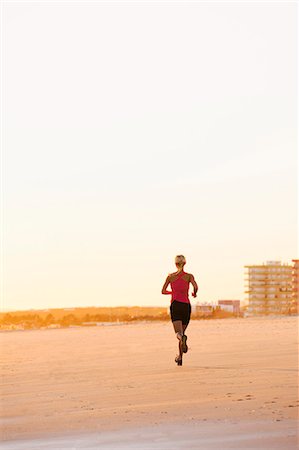 simsearch:6102-08120697,k - Woman running on beach at dusk Foto de stock - Sin royalties Premium, Código: 6102-07769356