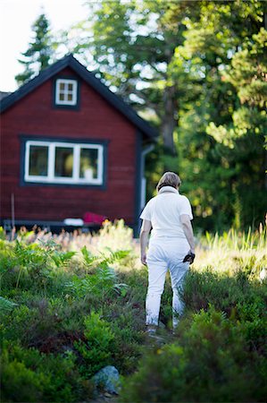 exterior color for house in the forest - Woman walking near house Stock Photo - Premium Royalty-Free, Code: 6102-07790142
