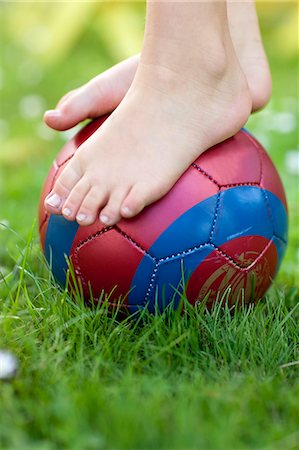 Childs feet on ball, close-up Stock Photo - Premium Royalty-Free, Code: 6102-07843290