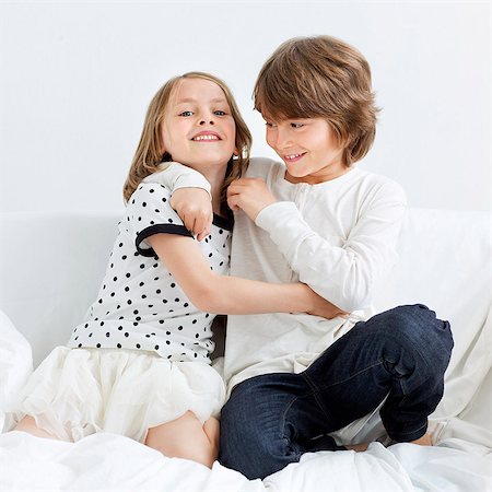 sister brother hugging two - Smiling boy and girl, studio shot Stock Photo - Premium Royalty-Free, Code: 6102-07843233