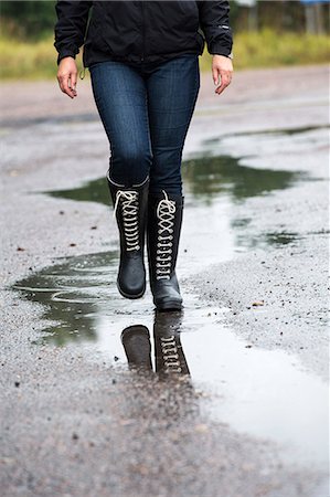 puddle in the rain - Woman walking through puddle, low section Stock Photo - Premium Royalty-Free, Code: 6102-07843832