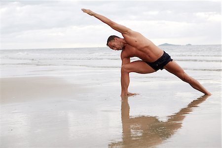 simsearch:6102-08942226,k - Man practicing yoga on beach Foto de stock - Sin royalties Premium, Código: 6102-07844043