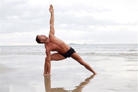 simsearch:6102-08942226,k - Man practicing yoga on beach Foto de stock - Sin royalties Premium, Código: 6102-07844044