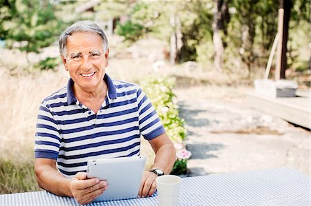 Portrait of smiling mature man with digital tablet Stock Photo - Premium Royalty-Free, Code: 6102-08063007