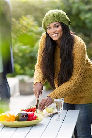 Smiling young woman cutting vegetables Stock Photo - Premium Royalty-Free, Code: 6102-08000727