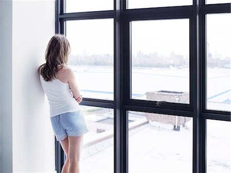 Girl looking through window Stock Photo - Premium Royalty-Free, Code: 6102-08000995