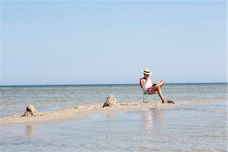 Mature man reading book on beach Photographie de stock - Premium Libres de Droits, Code: 6102-08000926