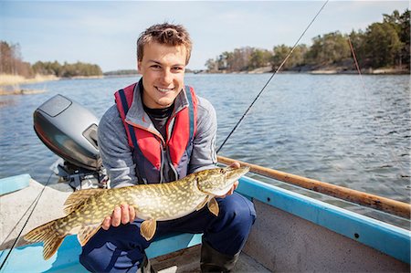 simsearch:6102-08001381,k - Young man holding caught fish Stock Photo - Premium Royalty-Free, Code: 6102-08001381