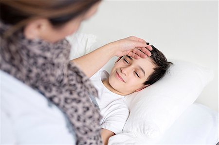 preteen on bed - Mother checking sons temperature Stock Photo - Premium Royalty-Free, Code: 6102-08168907