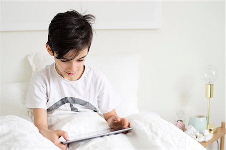 Boy in bed with digital tablet Stock Photo - Premium Royalty-Free, Code: 6102-08168915