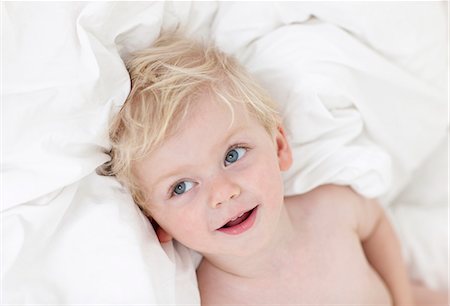 simsearch:6102-08168912,k - Smiling boy lying in bed Photographie de stock - Premium Libres de Droits, Code: 6102-08183935
