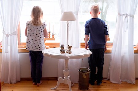 Boy and girl looking through window Stock Photo - Premium Royalty-Free, Code: 6102-08184102