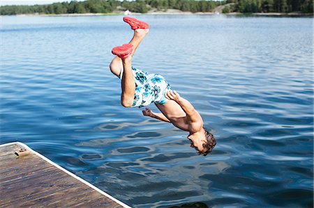 simsearch:6102-08001381,k - Teenage boy jumping into water Stock Photo - Premium Royalty-Free, Code: 6102-08120582