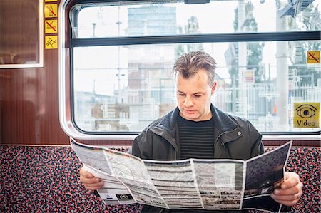 Man reading map in train Stock Photo - Premium Royalty-Free, Code: 6102-08120813