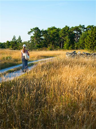 simsearch:6102-06026084,k - Woman walking on dirt track Stock Photo - Premium Royalty-Free, Code: 6102-08271213