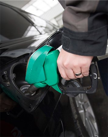 Hand holding petrol nozzle Stock Photo - Premium Royalty-Free, Code: 6102-08271462