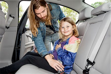 family inside car - Father checking daughters safety belt Stock Photo - Premium Royalty-Free, Code: 6102-08271515