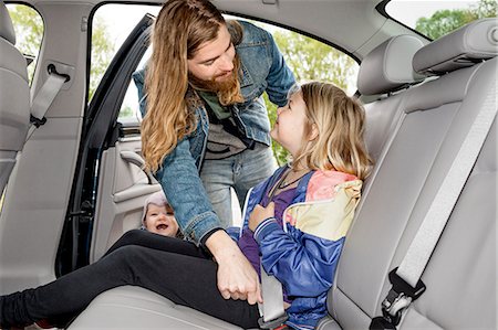 family inside car - Father checking daughters safety belt Stock Photo - Premium Royalty-Free, Code: 6102-08271516