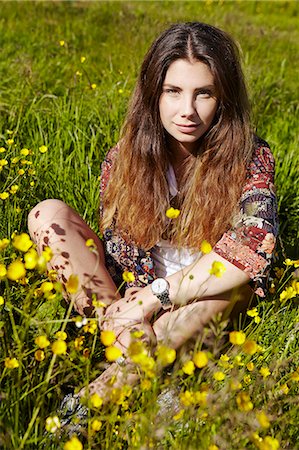 Young woman sitting on meadow Stock Photo - Premium Royalty-Free, Code: 6102-08271803