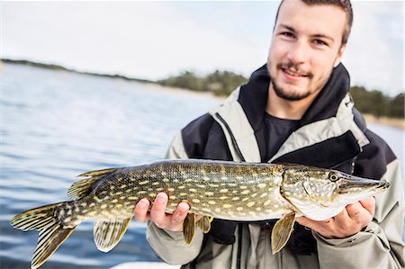 simsearch:6102-08001381,k - Young man holding pike Stock Photo - Premium Royalty-Free, Code: 6102-08278753