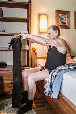 person in room - Senior man putting on trousers Stock Photo - Premium Royalty-Free, Code: 6102-08480953