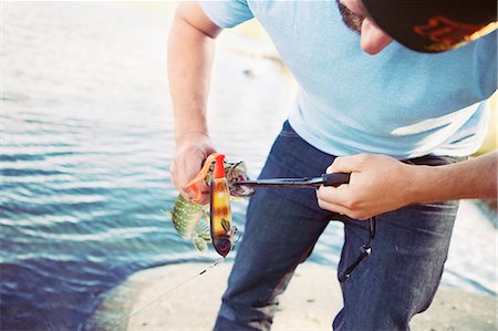 simsearch:6102-08001381,k - Young man holding fishing equipment Stock Photo - Premium Royalty-Free, Code: 6102-08481000