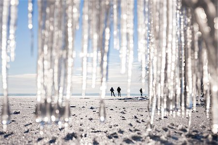 simsearch:6102-06337107,k - Silhouettes of people on beach. icicles on foreground Photographie de stock - Premium Libres de Droits, Code: 6102-08481010