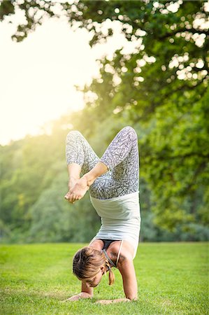simsearch:6102-08942226,k - Woman doing yoga in park Foto de stock - Sin royalties Premium, Código: 6102-08481172