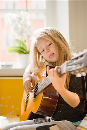Girl playing guitar in bedroom Stock Photo - Premium Royalty-Free, Code: 6102-08481283