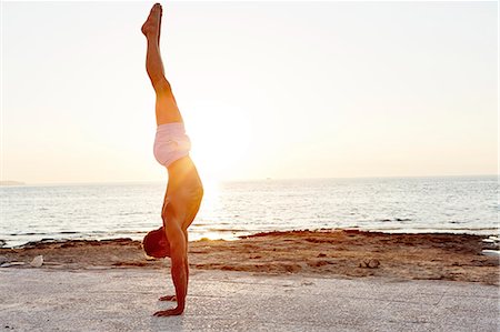 simsearch:6102-08942215,k - Man doing handstand on beach at sunset Stock Photo - Premium Royalty-Free, Code: 6102-08481320