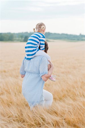 piggy back ride mom and child - Mother carrying daughter in field Stock Photo - Premium Royalty-Free, Code: 6102-08481445