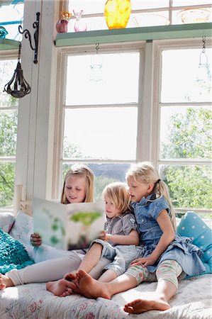 Three sisters reading book Stock Photo - Premium Royalty-Free, Code: 6102-08481565