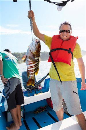 simsearch:6102-08001381,k - Pride man holding fish on fishing boat Stock Photo - Premium Royalty-Free, Code: 6102-08542375