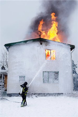 smoky - Fireman spraying water on burning building Photographie de stock - Premium Libres de Droits, Code: 6102-08558954