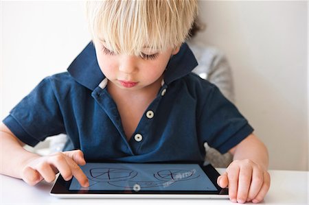 Boy drawing on digital tablet Stock Photo - Premium Royalty-Free, Code: 6102-08559262