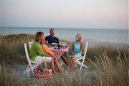 simsearch:6102-08542382,k - Family having picnic by the sea, Sweden. Stock Photo - Premium Royalty-Free, Code: 6102-08567001