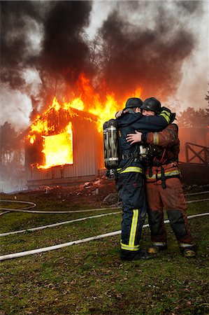 dangerous accident - Fire fighters embracing in front of burning buildings Stock Photo - Premium Royalty-Free, Code: 6102-08746253