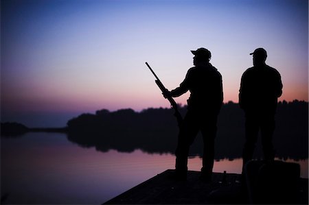 simsearch:6102-06337050,k - Silhouette of two hunters on jetty at sunset Stock Photo - Premium Royalty-Free, Code: 6102-08746265