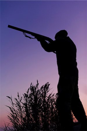 simsearch:6102-06337050,k - Hunter holding gun at lake at dusk Stock Photo - Premium Royalty-Free, Code: 6102-08746266