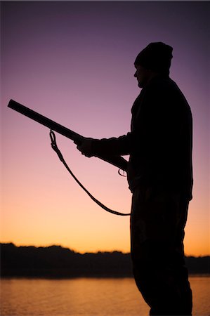 simsearch:6102-06337050,k - Silhouette of hunter holding gun at lake at dusk Stock Photo - Premium Royalty-Free, Code: 6102-08746268