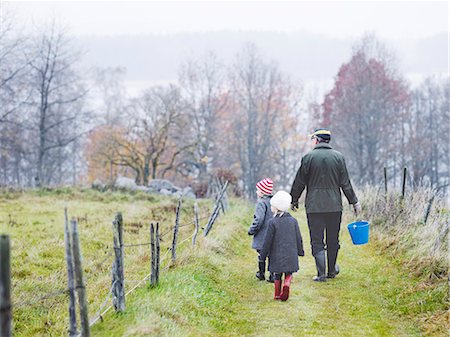 farmers family of three - Grandfather and granddaughters walking on footpath Stock Photo - Premium Royalty-Free, Code: 6102-08760275