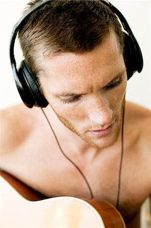 simsearch:6102-03748485,k - Young with headphones man playing guitar Stock Photo - Premium Royalty-Free, Code: 6102-08761661