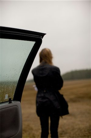 rainy day sad - A woman standing on a field in the rain, Gotland, Sweden. Stock Photo - Premium Royalty-Free, Code: 6102-08768735