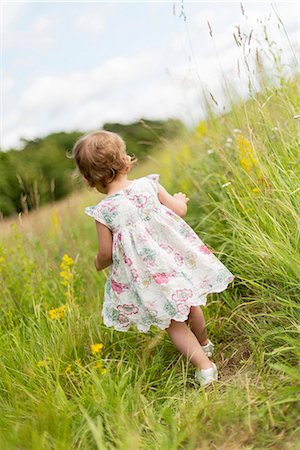 Little girl walking in meadow Stock Photo - Premium Royalty-Free, Code: 6102-08858572