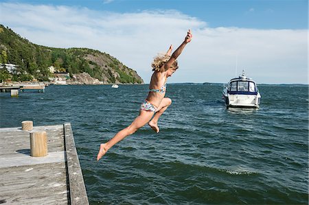 preteen swimsuit - Woman jumping into sea Stock Photo - Premium Royalty-Free, Code: 6102-08881519