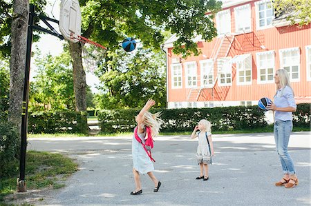 Mother playing basketball with daughters Stock Photo - Premium Royalty-Free, Code: 6102-08881677