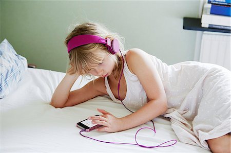 simsearch:6102-08168912,k - Girl with headphones using cell phone Photographie de stock - Premium Libres de Droits, Code: 6102-08881778