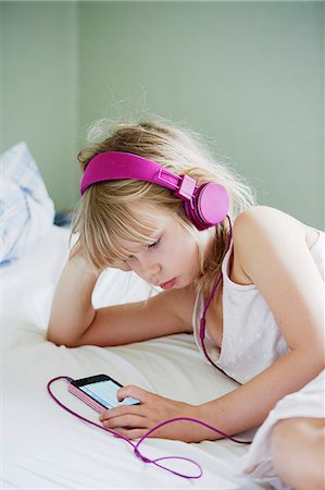 simsearch:6102-08168912,k - Girl with headphones using cell phone Photographie de stock - Premium Libres de Droits, Code: 6102-08881779